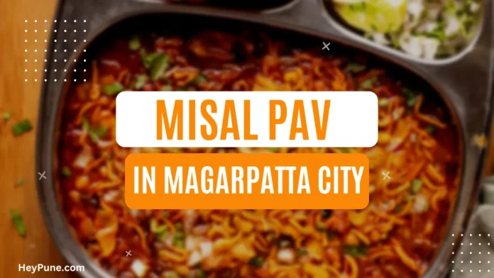 A plate of Misal Pav served with onions and lemon wedges.